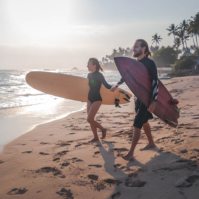 Happy young couple about to go surfing