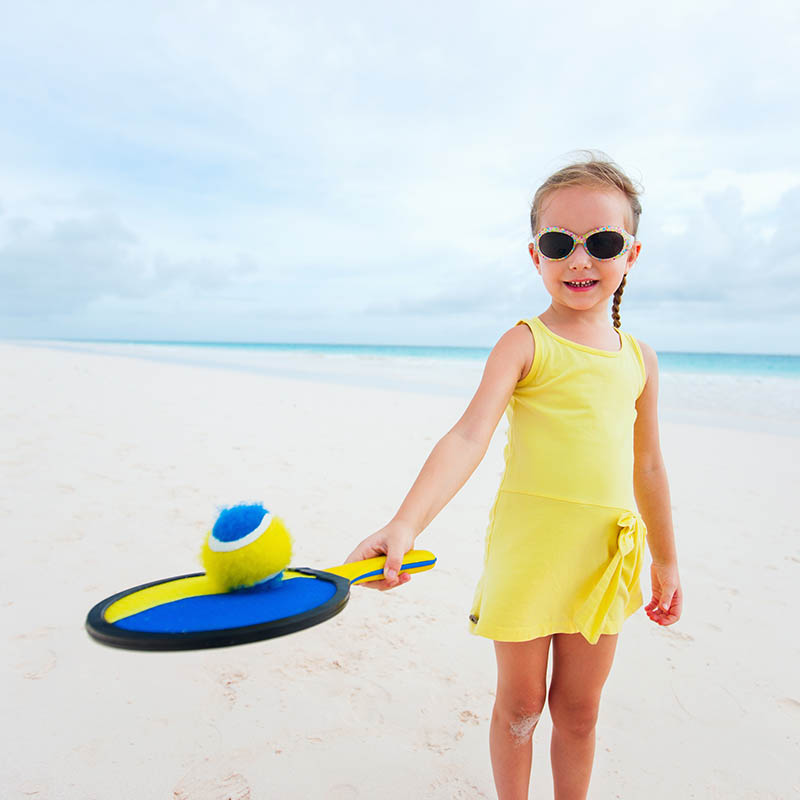 Little girl playing beach tennis