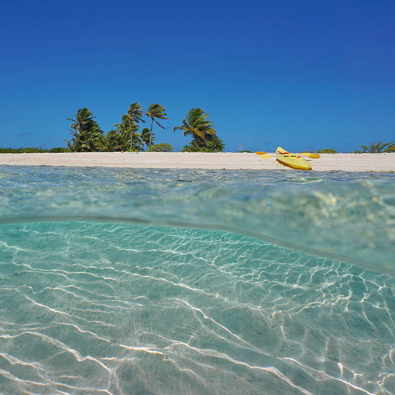 Tropical island sandy sea shore with a kayak on the beach