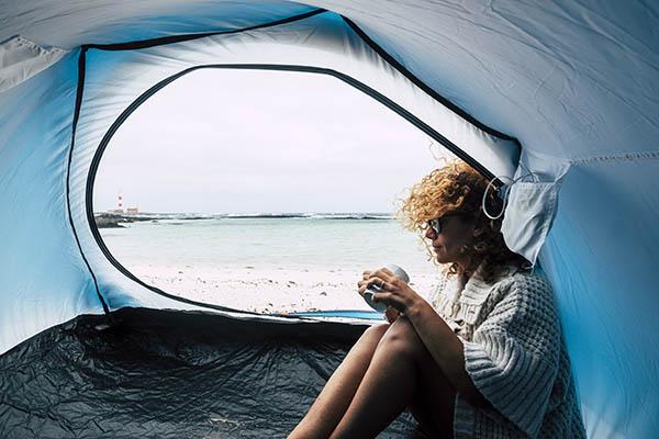 woman inside a tent camping at the beach