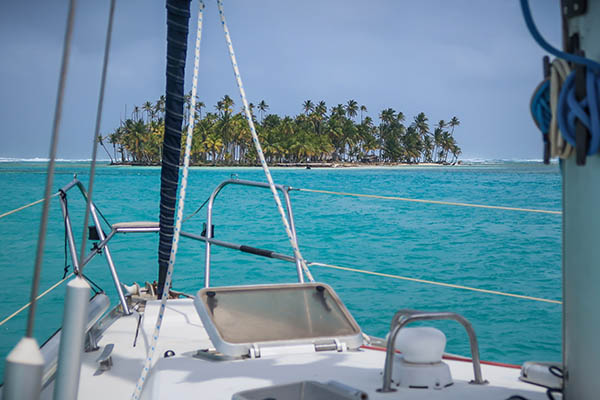 catamaran sailing close by a tropical island in the Caribbean