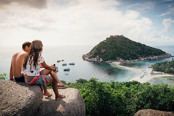 Young couple sitting looking at a view of Koh Nang Yuan island in Thailand