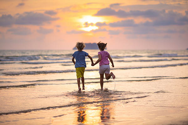 Little boy and girl running on exotic island during summer holiday