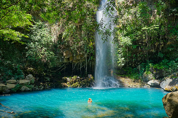 Woman at a waterfall in Rincón de la Vieja Volcano National Park