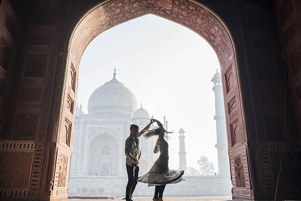 Romantic honeymoon couple dancing at the Taj Mahal, India