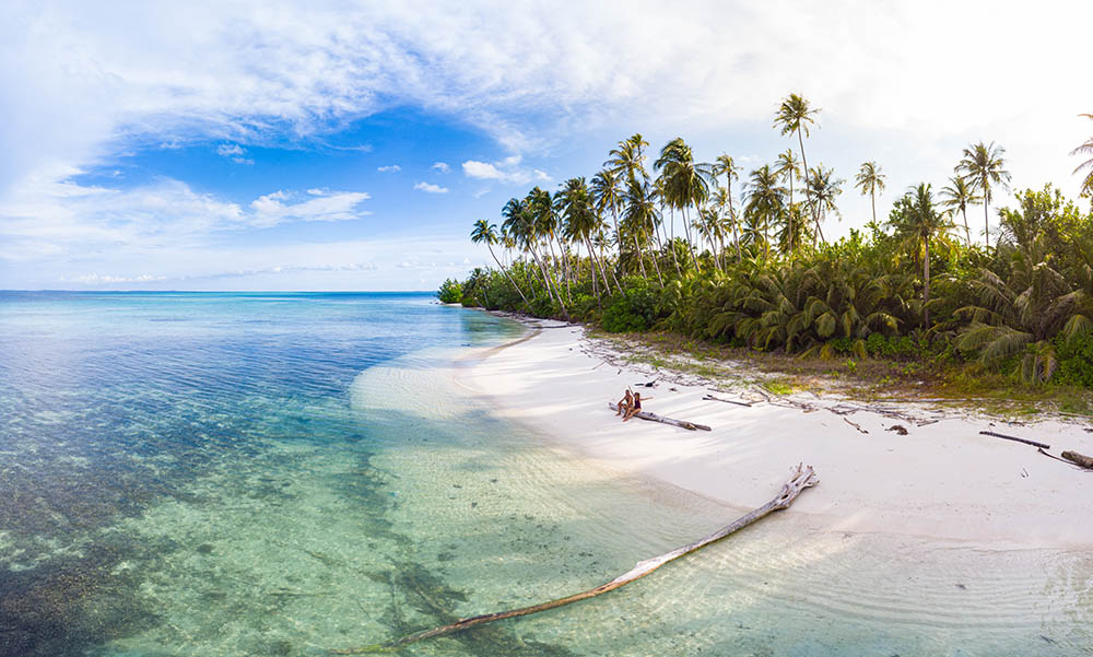 Honeymoon couple relaxing on tropical beach