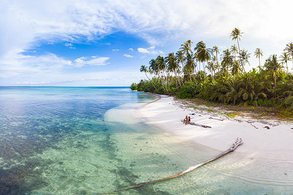 Honeymoon couple relaxing on tropical beach