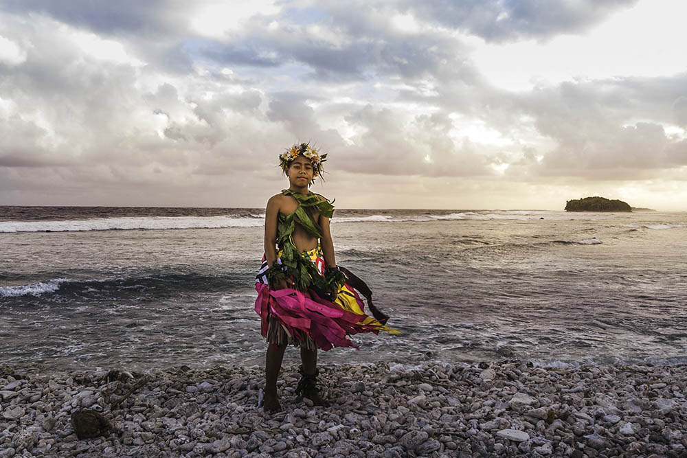 Young boy in traditional costume on the beach at sunset in Tuvalu