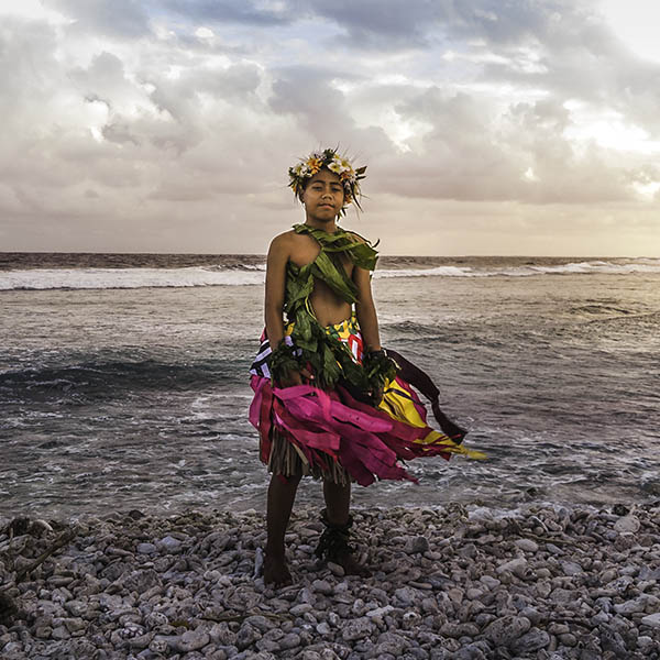 Young boy in traditional costume on the beach at sunset in Tuvalu