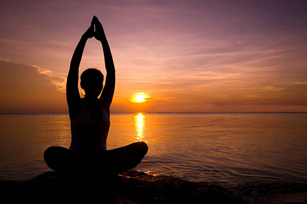 Girl in yoga pose at sunset on Lake Malawi