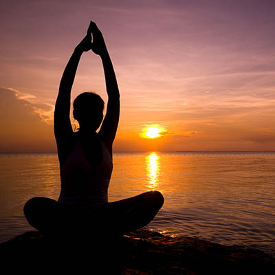 Girl in yoga pose at sunset on Lake Malawi