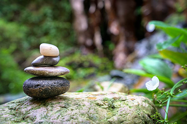 Pebble tower with green nature and water background