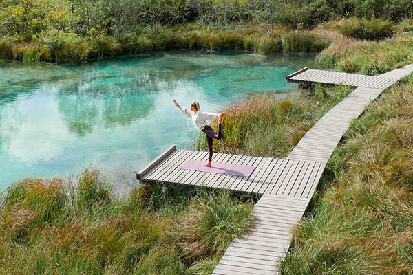 young woman doing yoga in beautiful nature at a mountain