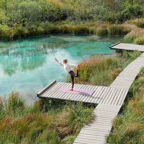 young woman doing yoga in beautiful nature at a mountain