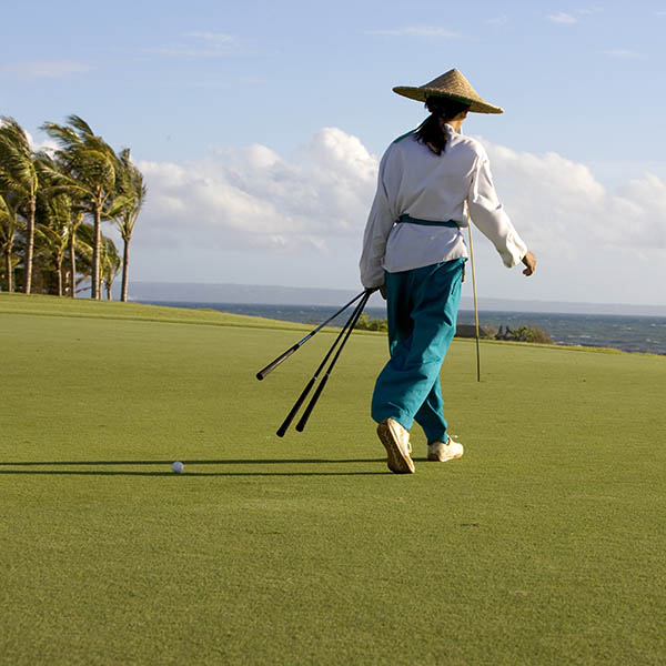 Asian woman walking on a golf course in Indonesia