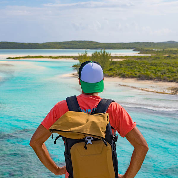 Male tourist with backpack hiking on Long Island in the Bahamas