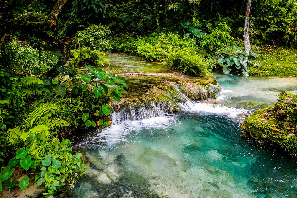 Water flows down the Mele Cascades waterfalls among lush jungle in Efate Island, Vanuatu, near Port Vila