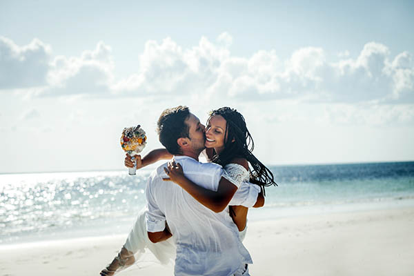 Newlywed couple hugging on the beach