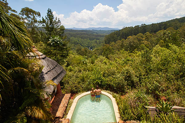 Aerial view of couple in a small swimming pool looking out over the forest at a lodge in South Africa