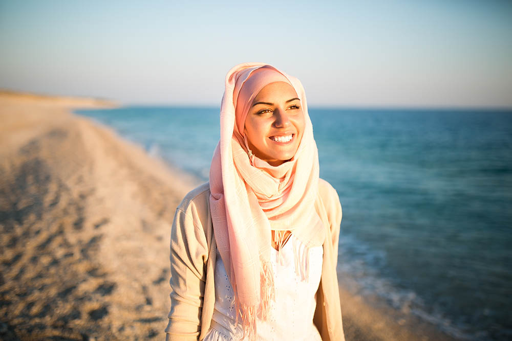 Beautiful arab woman on the beach with the sea in the background