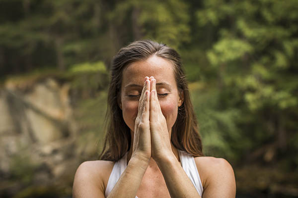 Happy girl meditating in a tropical forest