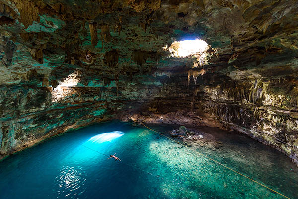 Woman swimming in cenote Samula Dzitnup near Valladolid, Yucatan, Mexico