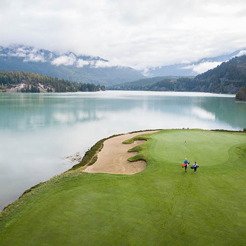 High angle view over golfers walking towards the putting green on a golf course in British Columbia, Canada