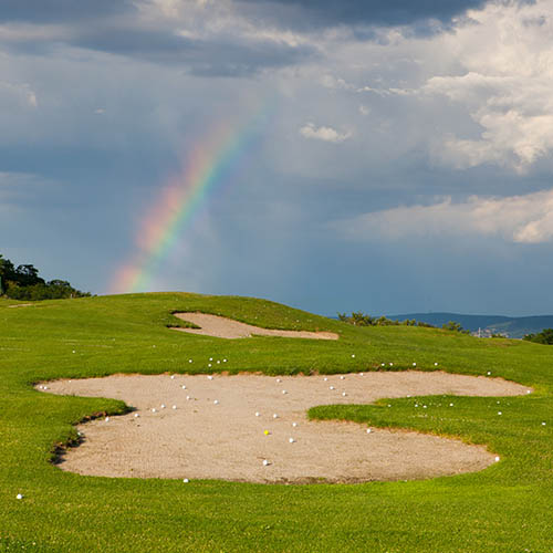 Rainbow on an empty driving range after a storm