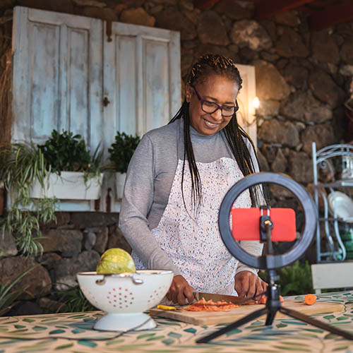 African senior woman streaming online virtual masterclass cooking lesson outdoors at home