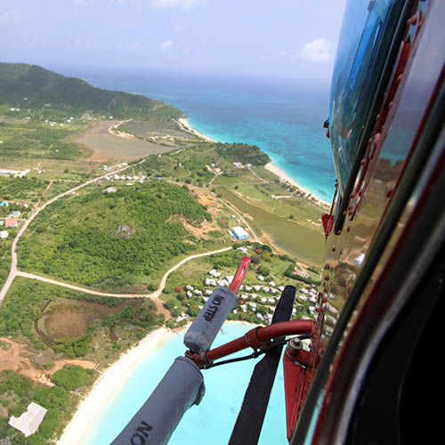 A helicopter flies over the Caribbean island of Antigua