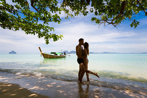 Couple kissing on a beach while on honeymoon on Koh Kradan, Thailand