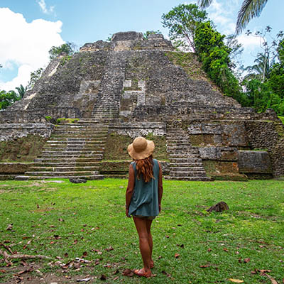 Woman standing looking at a Mayan ruin in Belize