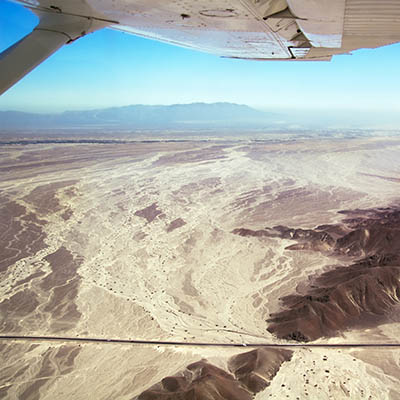 Nazca desert and panamerican highway seen from above, under the wing of a Nasca Lines airplane. Peru