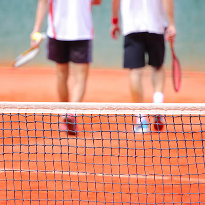 Back view of two players at a tennis court