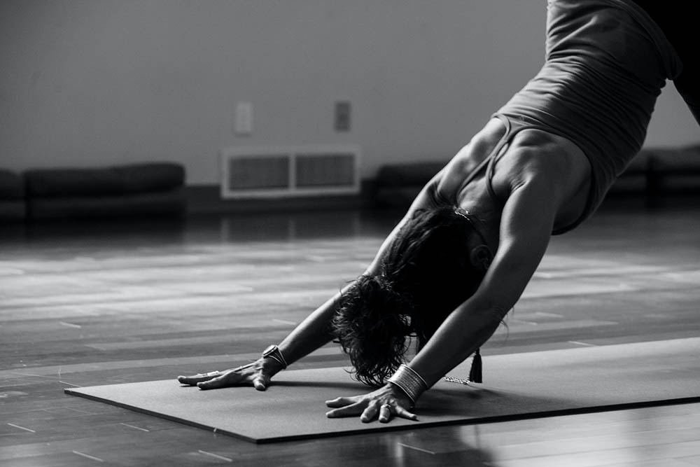 Black & White image of a woman in a yoga class