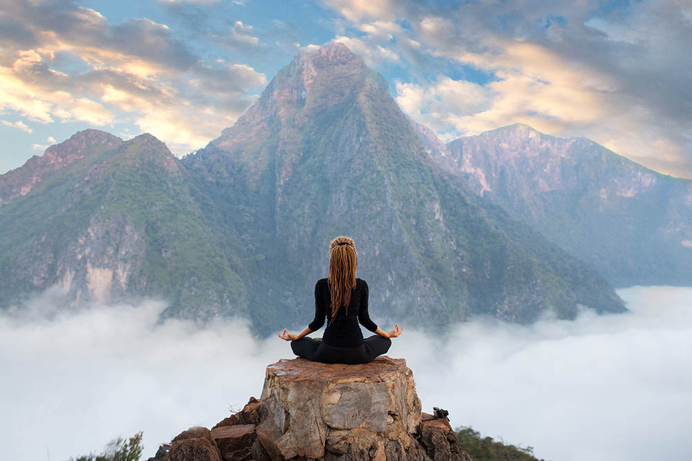 Girl sitting in yoga pose at the Nong Khiaw viewpoint in Northern Laos