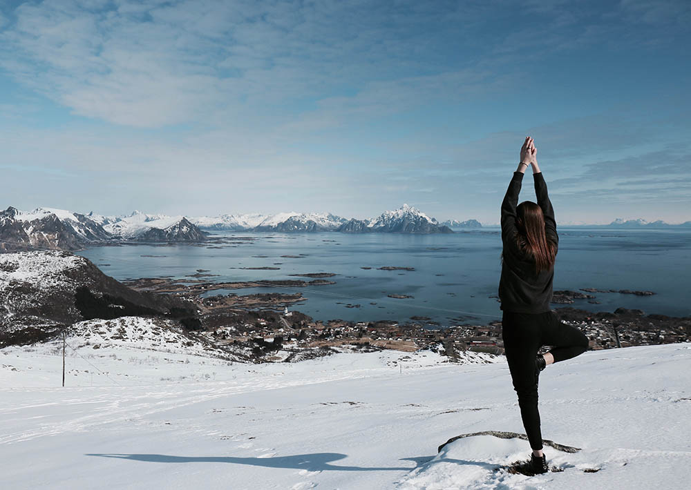 Woman standing in yoga position in the Lofoten Islands, Norway