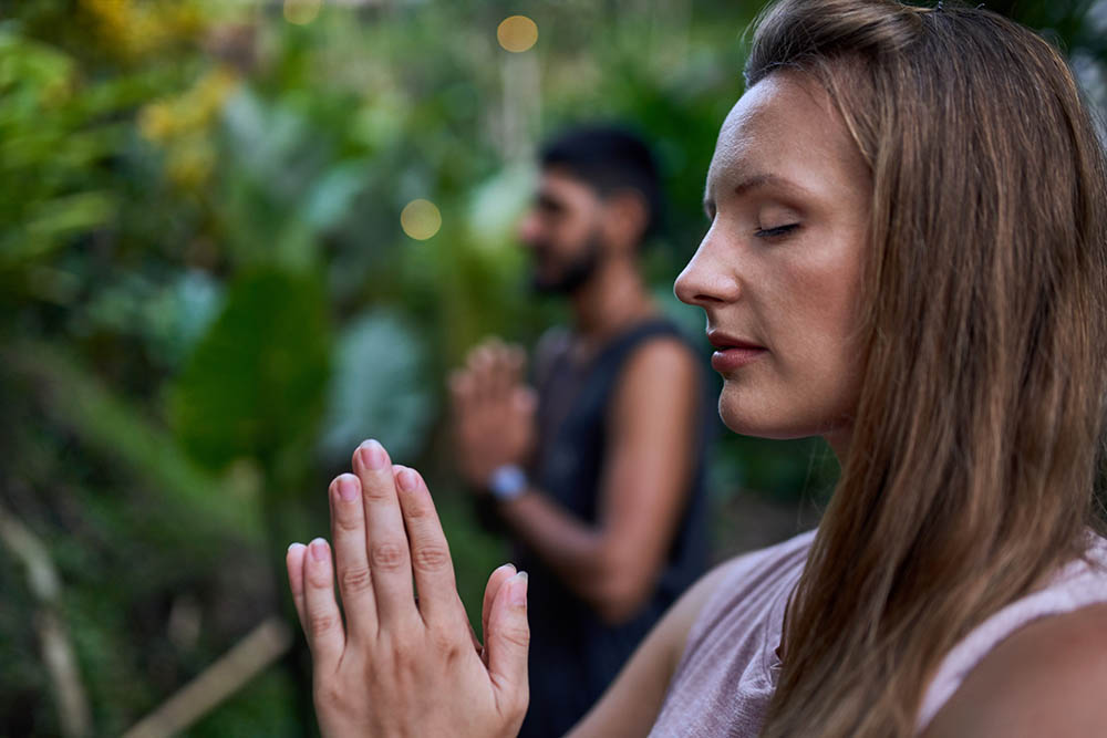 Man and woman praying together yoga and meditation session outdoors