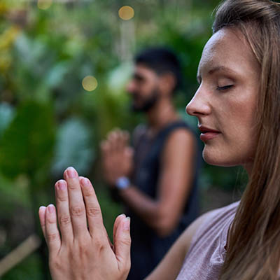 Man and woman praying together yoga and meditation session outdoors