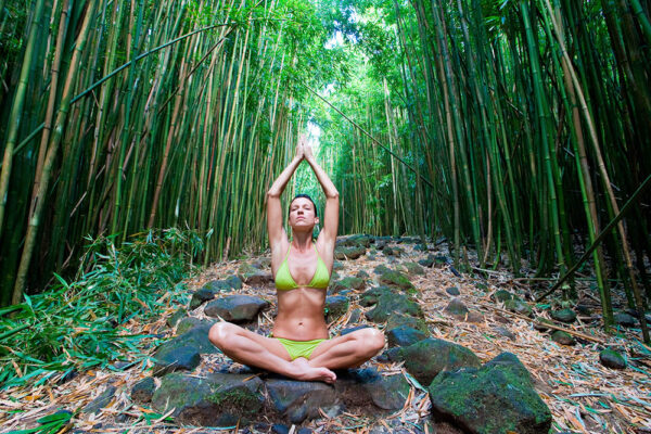 Girl doing yoga on a bamboo path in Hawaii