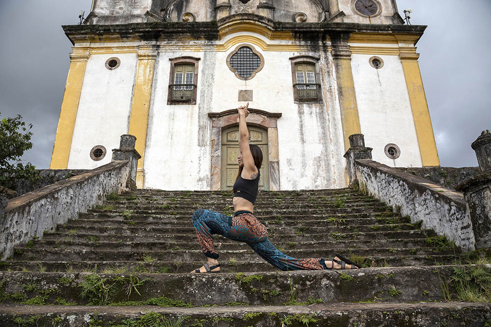 Latin woman practicing yoga in front of ancient building in Brazil