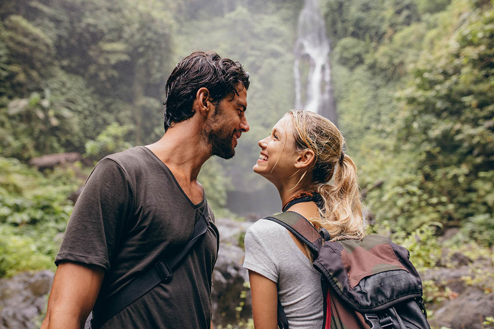 happy young couple together by a waterfall in Colombia