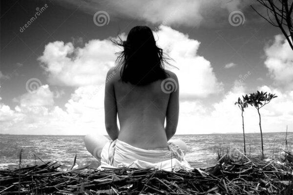 Black and white photo of a woman practicing yoga on a tropical beach