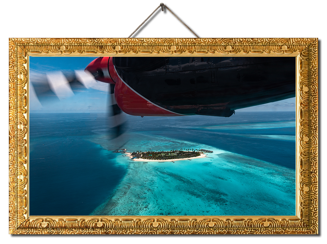 Image of Seaplane flying over an island in the Maldives in a gold frame